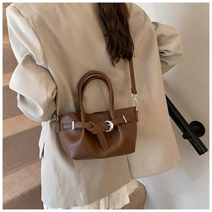 Détail d'un sac cabas marron vintage avec une boucle lune argentée sur un sac bandoulière