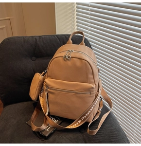 Close-up of khaki leather backpack with textured grain and woven pattern strap