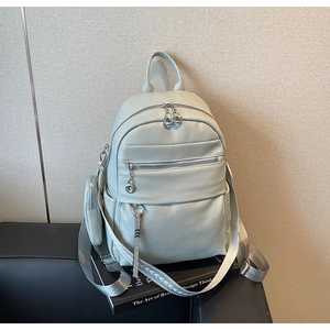 Detail of mint green lychee PU leather backpack with wide printed strap and mini pouch