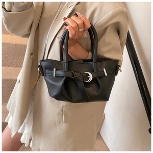 Détail du sac seau noir élégant avec anneau en métal argenté et finition en cuir mat