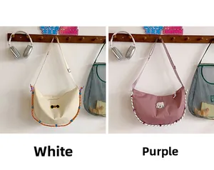 Borse a tracolla in nylon con ricami a fumetti nei colori crema e viola chiaro
