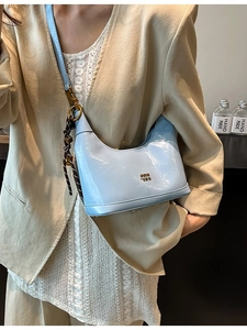 Borsa a tracolla a mezzaluna in pelle cerata azzurra con ciondolo intrecciato e logo