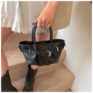 Détail du sac seau noir avec ouverture plissée et boucle en métal argenté élégante