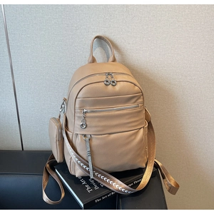 Detail of lychee pattern leather backpack with colorful woven straps and mini pouch