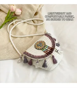 Dettaglio borsa a tracolla intrecciata bianca con nappe colorate e decoro di perline