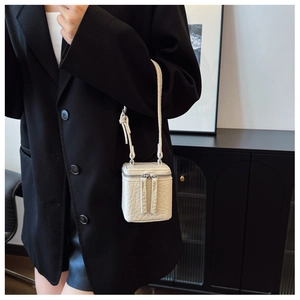Chic cream mini box bag with textured finish shown on a black oversized blazer
