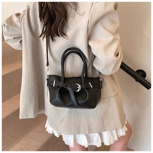 Vue latérale du sac seau en cuir noir avec boucle argentée et bandoulière fine