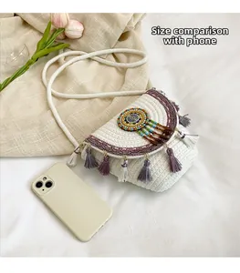 Detail of bohemian woven straw bag with colorful beads, tassels, and a phone for size reference