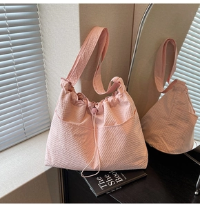 Close-up of light pink waffle texture fabric tote bag with functional front drawstring pockets