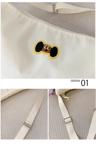 Dettaglio borsa in nylon crema con ricamo, tracolla regolabile e cerniera viola