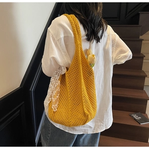 Détail du sac cabas en tricot jaune avec motif en maille ajourée et ruban en dentelle