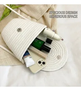 Dettaglio dell'interno capiente di una borsa a tracolla intrecciata bianca con trucchi