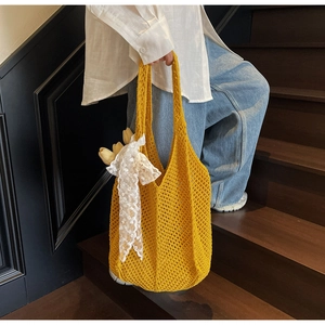 Détail d'un sac shopping en maille jaune avec nœud en dentelle et tulipes décoratives