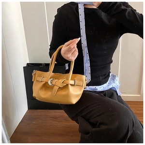 Détail du sac seau jaune vif avec boucle argentée et texture en cuir PU lisse