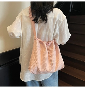Detailed view of pink checkered drawstring tote bag with functional side pockets