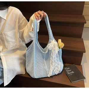 Détail du sac cabas en crochet bleu clair avec nœud en dentelle et maille ajourée