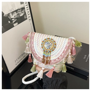 Dettaglio della borsa a secchiello etnica intrecciata con nappe colorate e ricami di perline