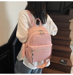 Detail of pink pebbled leather backpack with double zippers and stylish woven straps