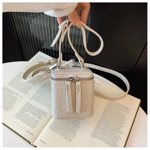 Detailed macro of beige croc-embossed mini box bag with silver hardware and zippers