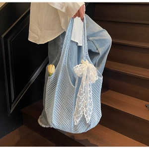 Détail de la texture en crochet bleu clair avec nœud décoratif en dentelle blanche
