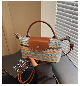 Detail of colorful woven straw bag with brown leather flap and stylish handle