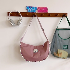 Dettaglio borsa dumpling in nylon rosa con toppa a cane e bordo in corda intrecciata