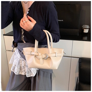 Vue détaillée du sac seau en cuir beige avec design plissé et boucle en métal doré