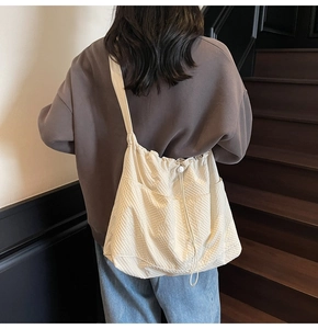 Close-up of beige woven tote bag with drawstring closure and functional multi-pockets