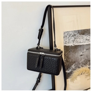 Detail of black textured leather mini crossbody box bag with silver zippers and strap