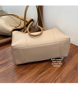 Detail of metal feet on the bottom of a large faux leather tote bag for wear protection