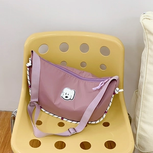Dettaglio della borsa a mezzaluna in nylon lilla con patch di cane e finiture in corda