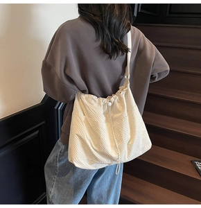 Detail of minimalist drawstring nylon bucket bag with textured fabric and adjustable strap