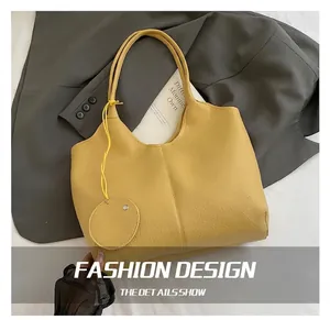 Détail du sac cabas en cuir jaune grainé avec son petit porte-monnaie assorti