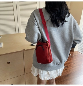 Detailed back view of a mini red nylon bucket bag showing textured fabric and strap