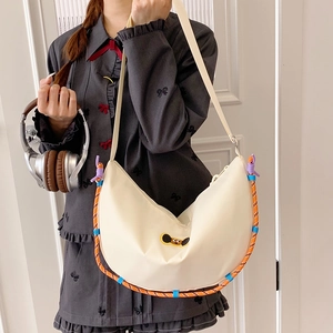 Dettaglio della borsa a tracolla in nylon bianco crema con finiture in corda intrecciata