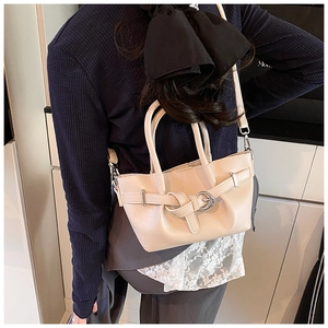 Vue arrière d'un mannequin portant le sac seau crème dans un intérieur moderne