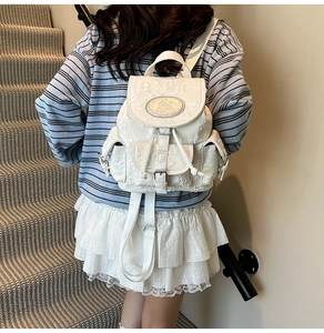 Detail des weißen Rucksacks mit floralem Jacquard-Muster und Metall-Steckschnalle