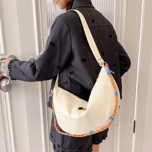 Dettaglio borsa a mezzaluna in nylon bianco crema con decorazione in corda intrecciata