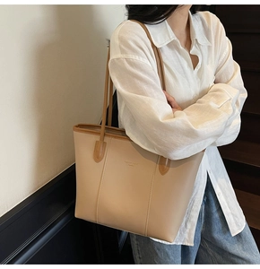 Chic tote bag in light apricot faux leather styled as a daily commuter shoulder bag