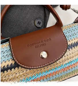 Detail of colorful hand-woven straw bag with premium brown leather flap and metal snap