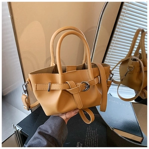 Détail du sac seau jaune clair avec boucle métallique réglable et texture de cuir mat