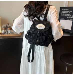 Nahaufnahme des schwarzen Rucksacks mit Blumenprägung und Metallverschluss-Schnalle