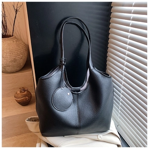Détail du sac cabas en cuir grainé noir avec texture souple dans un décor de maison chic