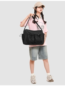 Dettaglio borsa a tracolla in nylon nero con due tasche a coulisse e tracolla regolabile