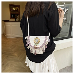 Dettaglio della borsa boho intrecciata con nappe viola e ricami etnici vivaci