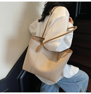 Detail of the chic beige tote bag showing high-capacity design and brown leather straps