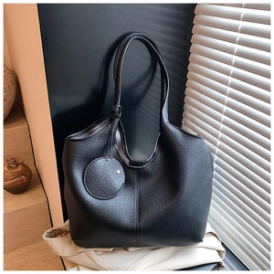 Détail du sac cabas noir à grain litchi avec une petite pochette ronde amovible en pendentif