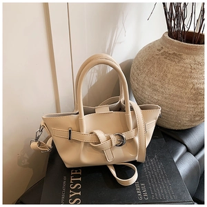 Détails du sac seau crème avec nœuds en cuir et finitions métalliques argentées