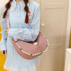 Dettaglio della borsa color malva con corda intrecciata e toppa a cartone animato