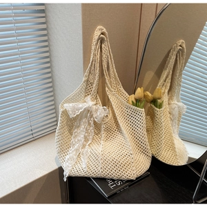 Détail d'un sac cabas en crochet blanc avec nœud en dentelle et décoration